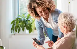 young woman showing older woman communication on smart phone