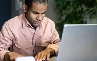 Visually impaired man using the laptop in the office