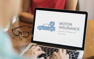 Person looking at a laptop screen that says motor insurance with a picture of a 2d car and a tick above it.