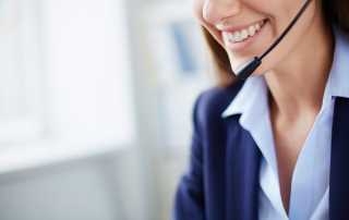 Smiling customer service representative wearing a headset.